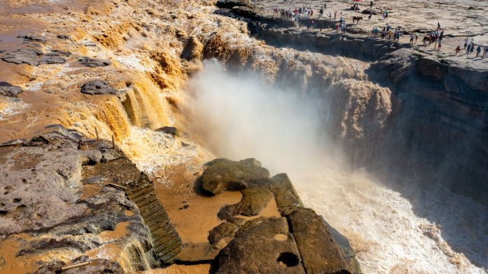 Flood water pounding against a canyon wall